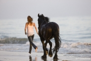 Summerland Beach, Ojai, CA, horse, purebred Friesian gelding and woman running on beach