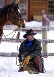 cowboy in snow with dog and horse, Flitner Ranch, Shell, WY