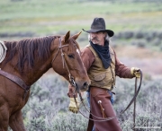 Cowboy leading sorrel Quarter Horse at Sombrero Ranch, Craig, CO