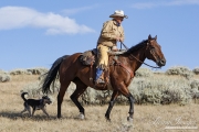 Flitner Ranch, Shell, WY - cowboy riding with cowdog
