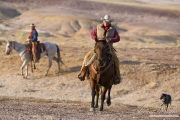 Flitner Ranch, Shell, WY - cowboy riding with cowdog following, cowboy in background