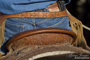 Detail of back of cowboy's saddle, jeans and chaps, Sombrero Ranch, Craig, CO