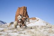 cowboy on grey Quarter horse running in the snow at Flitner Ranch, Shell, WY