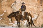 cowboy on paint horse standiing in the snow at Flitner Ranch, Shell, WY