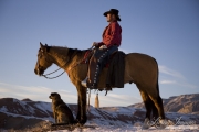 Cowboy and quarter horse and dog look out over the canyon at Flitner Ranch, Shell, WY