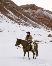 cowgirl on quarter horse standing in the snow at Flitner Ranch, Shell, WY