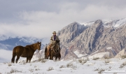 Flitner Ranch, Shell, WY, horses in winter, cowboy on horse holding another horse