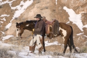 Flitner Ranch, Shell, WY, horses in winter, cowboy stands next to horse
