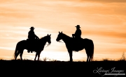 Flitner Ranch, Shell, WY, horses in winter, cowboys stand together at sunset on horses
