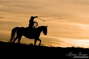 Flitner Ranch, Shell, WY, horses in winter, cowboy walking and swinging a loop at sunset